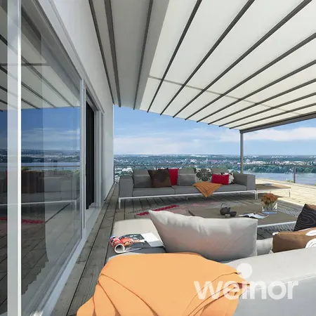Moderne Terrasse mit Markise, gemütlicher Sitzgruppe und Ausblick über die Stadt.