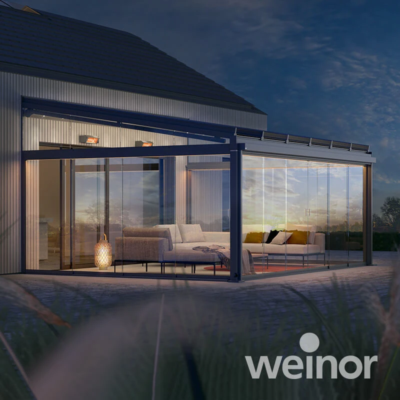 Moderne Terrassenüberdachung mit Glaswänden und stilvoller Lounge bei Sonnenuntergang.